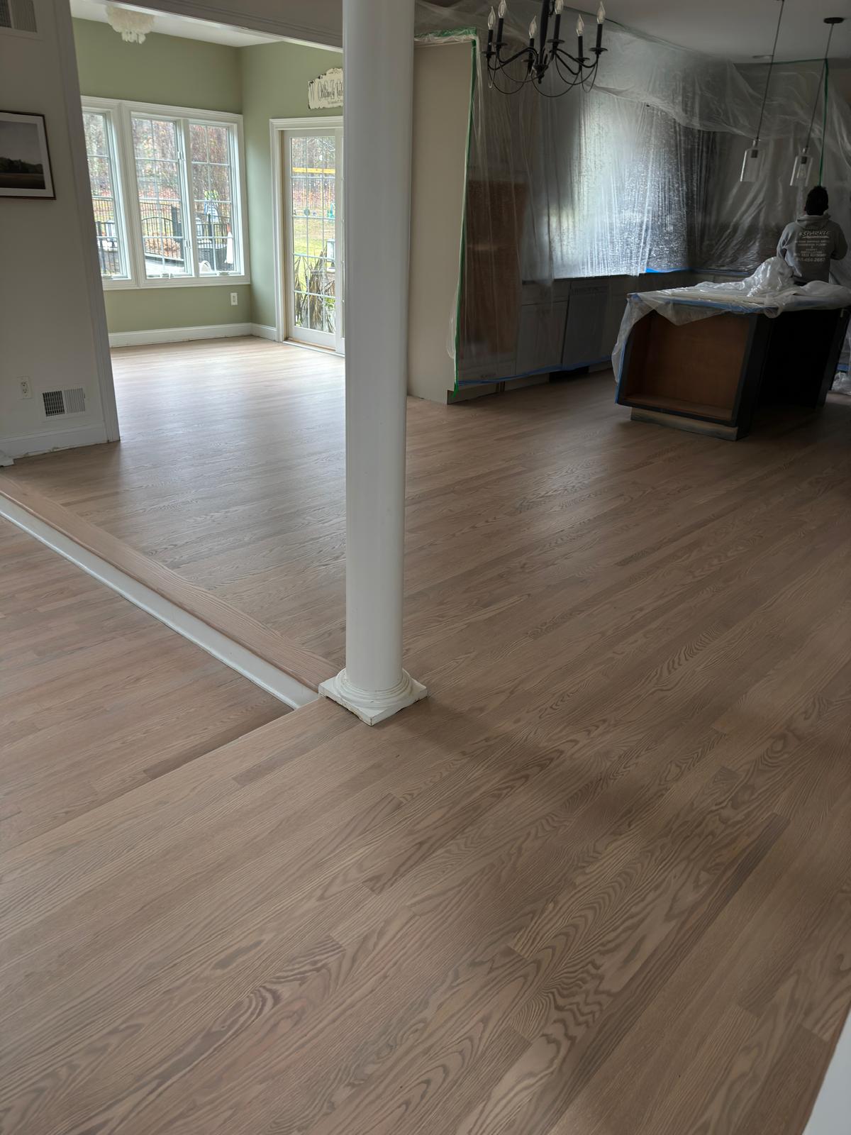 Refinished hardwood floor in a living room with a column